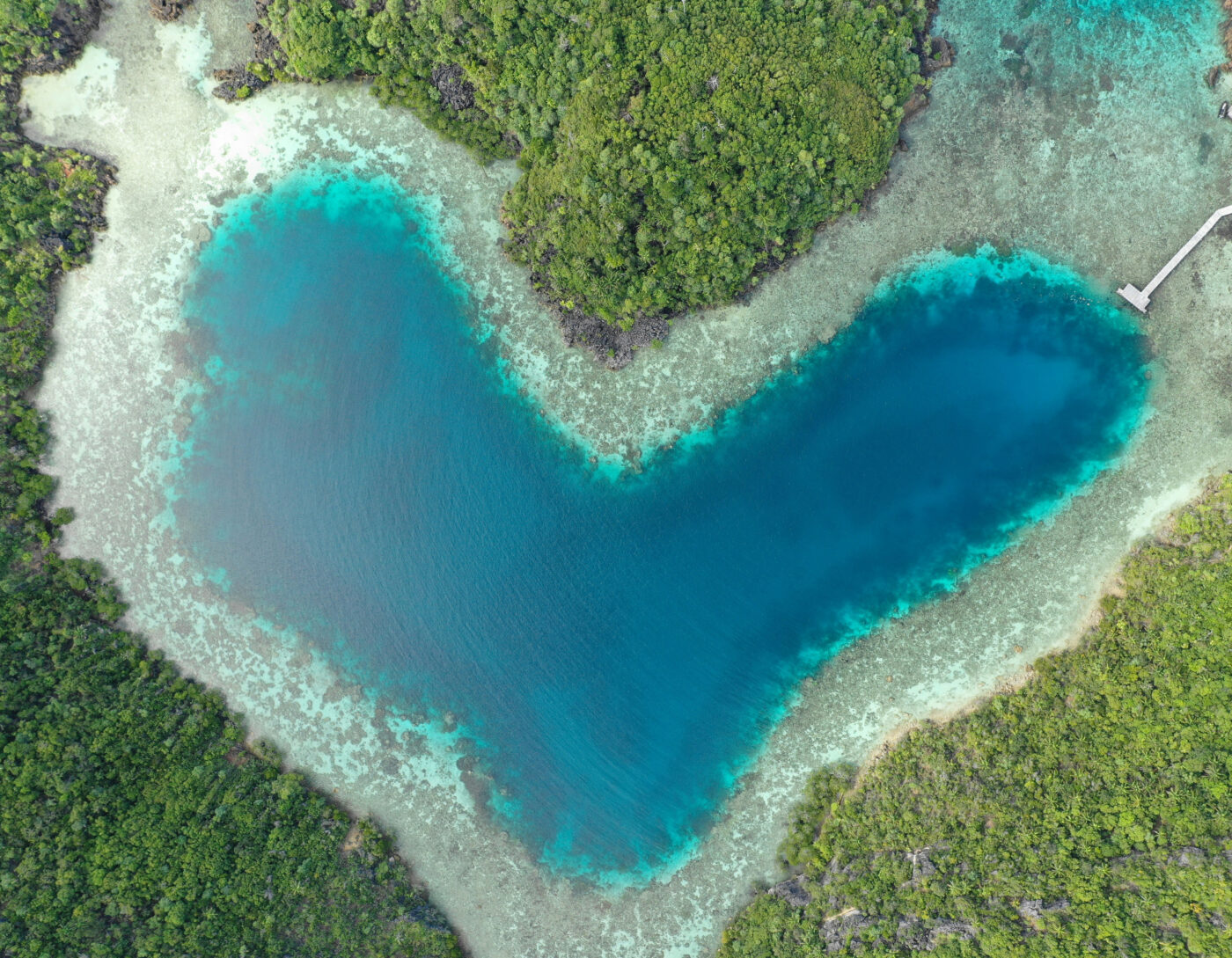 Aerial view of Love Lake in Raja Ampat, surrounded by lush jungle and turquoise waters.