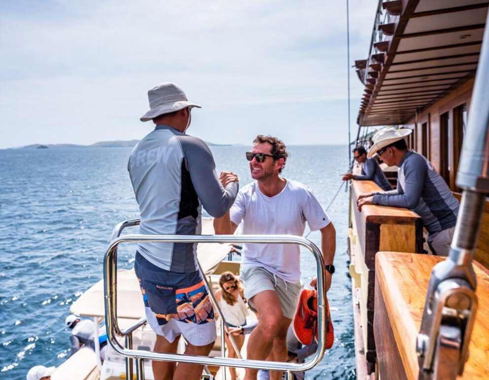 Guests arriving at a luxury charter yacht, warmly welcomed by the crew.