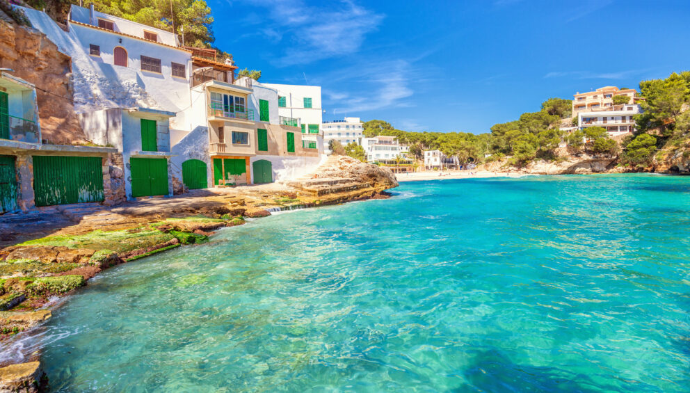 Beautiful traditional boathouses, apartments and beach at Playa Santanyi, located in the south east of Mallorca (Spain).