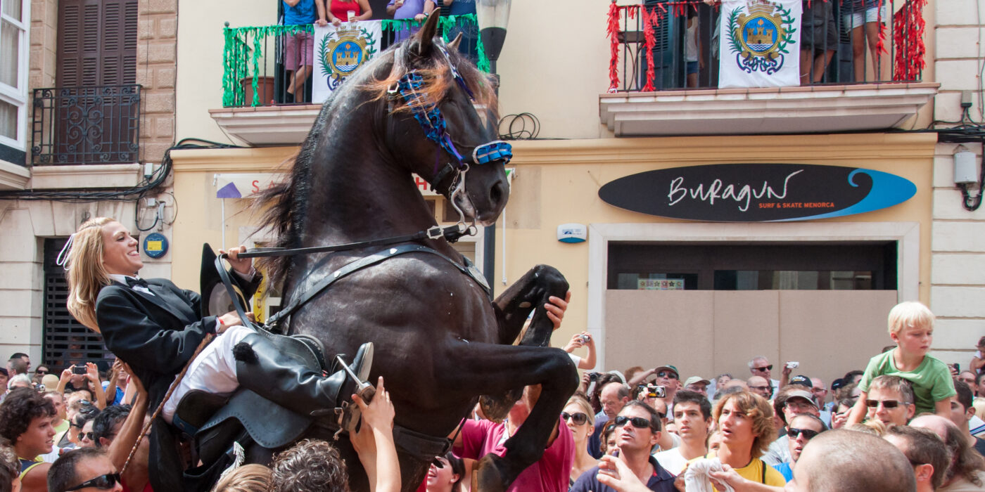 City of Mahon, Menorca, Spain - September 8, 2012: Fiestas de La Mare de Déu de Gràcia. This festival marks the end of Minorca's busy summer and it is one of the highlighted events of the annual festival calendar, which takes place in the capital, Mahon. The beautiful black horses from the local area are paraded spectacularly throughout the streets. The festival is concentrated near the Plaza del Ayuntamiento in the city centre and horses are ridden by professional riders who show off their skills and perform elaborate acts for the crowds. After the parade of the day, people gather to the city centre for music and dancing.