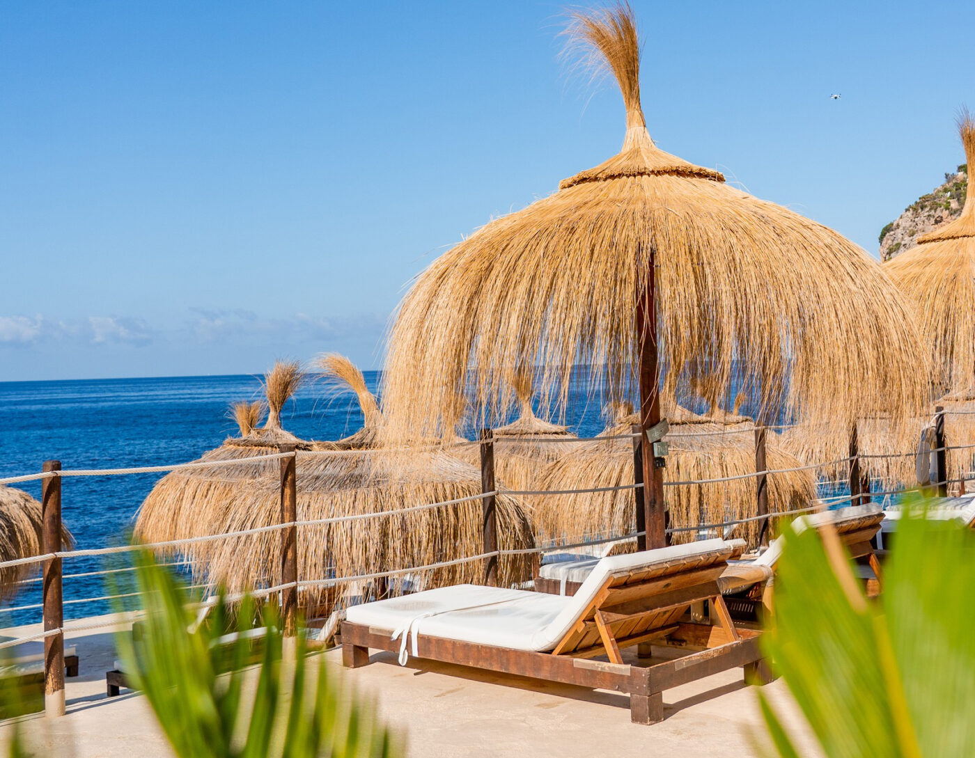 Gran Folies Beach Club with straw umbrellas by the sea