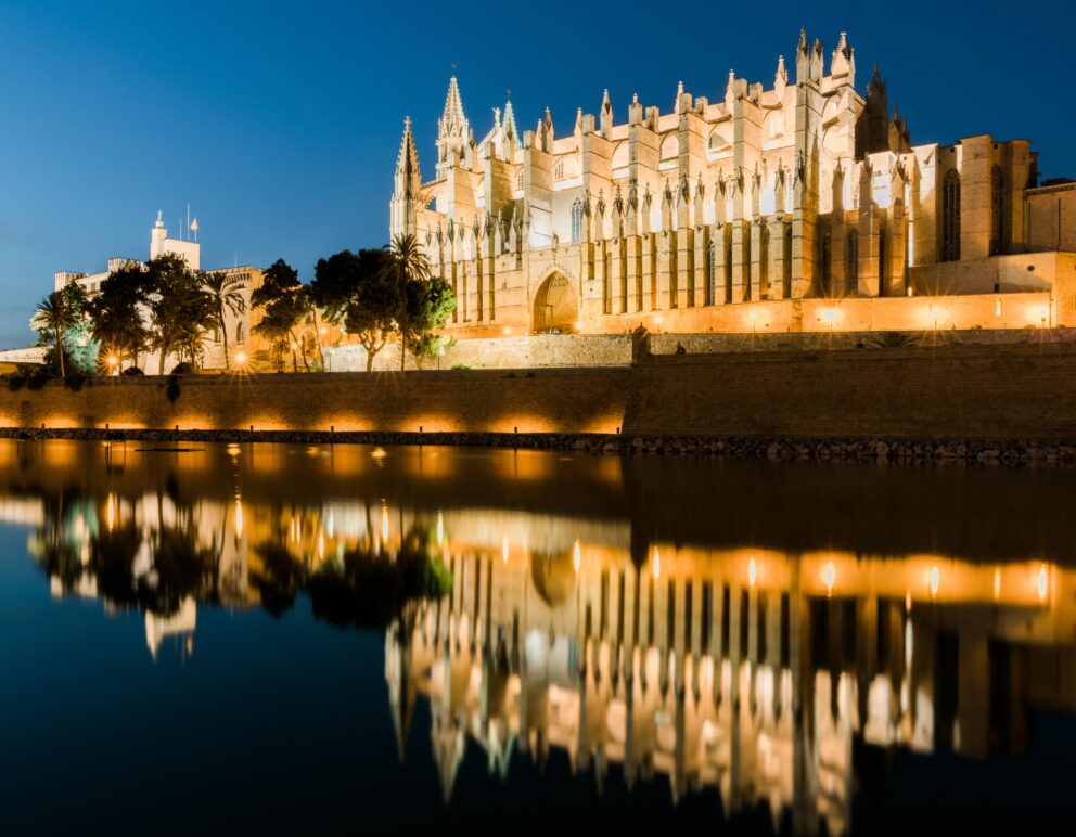 Palma Cathedral illuminated at night overlooking the bay