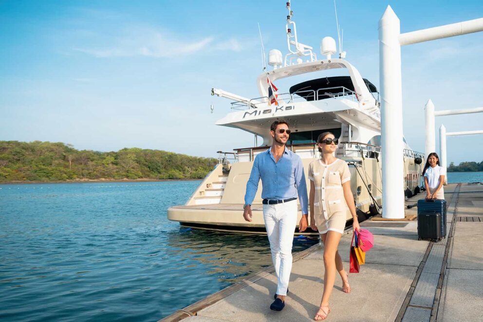 Two smiling guests disembark from the luxury yacht Mia Kai at the marina
