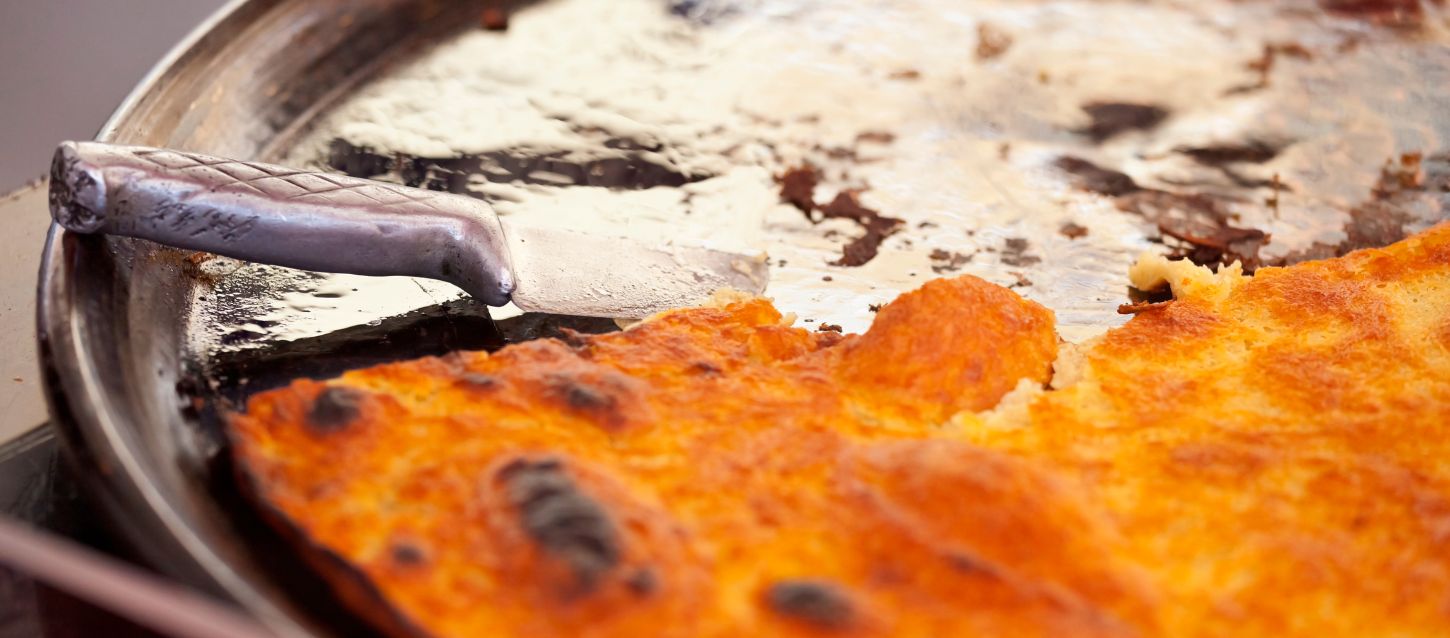 A close-up of a handcrafted metal handle on a rustic surface, warm earthy tones and local details