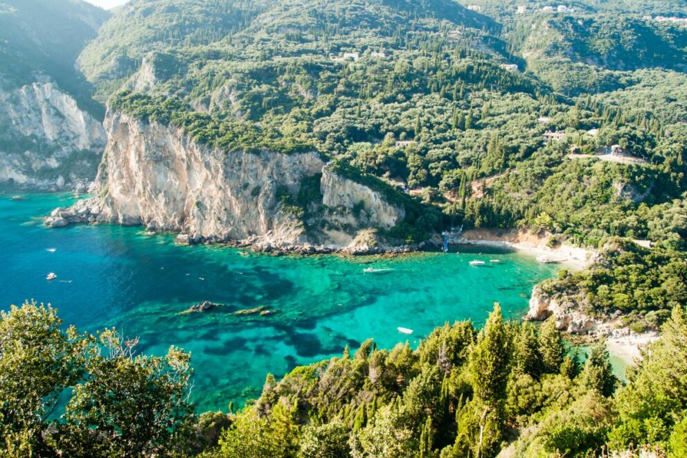 View of Paleokastritsa with cliffs, green hills, and turquoise waters