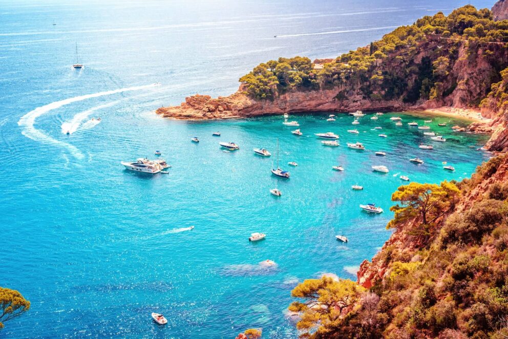 Costa Brava cove with yachts and catamarans anchored