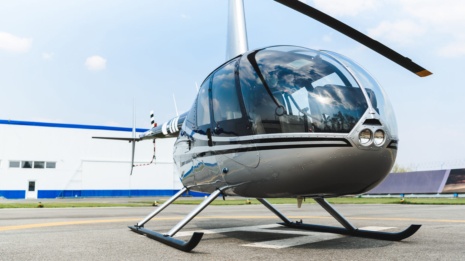 A silver and black Robinson R44 helicopter